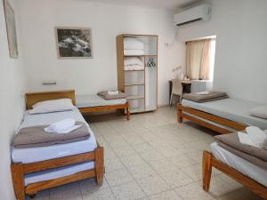 a room with two beds and a desk with a mirror at SPNI Golan Field School in Qasrîne