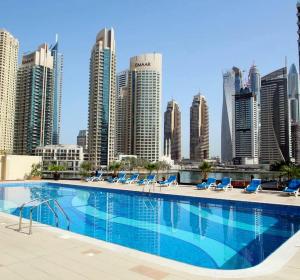 a swimming pool with chairs and a city skyline at Khayali Marina Holiday Homes Dubai Marina JBR in Dubai