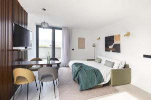 Un dormitorio con una cama y una mesa y sillas. en master La Rambla, en Barcelona