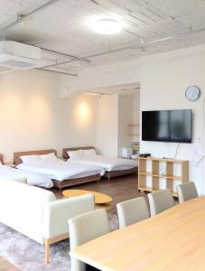 a room with three beds and a flat screen tv at キュリナリーBed and Art in Hamamatsu