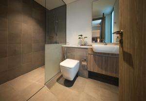 a bathroom with a toilet and a sink at Luxury Villa in Ajmal Makan with private pool in Al Ḩamrīyah +52 photos