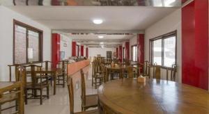 un restaurant avec des tables et des chaises en bois et des murs rouges dans l'établissement 169 Business Hotel, à Pékin