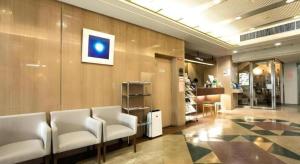 a waiting room with white chairs in a building at Green Hill Hotel Urban in Kobe