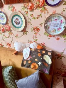 a box with a stuffed animal sitting on a wall with plates at Central Antique Gallery Apartment by the River -Self Check-in in Klaipėda