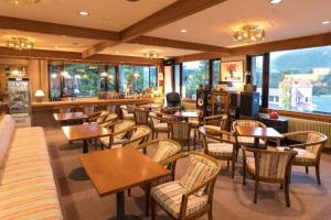 un restaurant avec des tables, des chaises et des fenêtres dans l'établissement Espoir Misawa, à Chikuni
