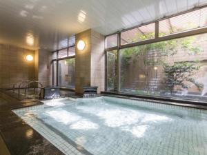 a swimming pool in a building with a large window at Nagoya B's Hotel in Nagoya