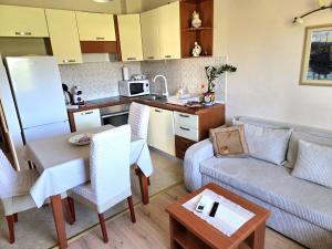 a kitchen and living room with a couch and a table at Apartman Sofia za 3 s parking blizu centra in Mlini +30 photos