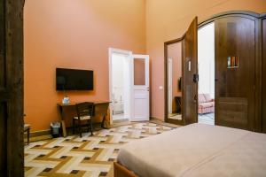 a bedroom with a bed and a desk and a television at Beit Toureef - SARAYA HALA 'PALATIAL' in Beirut