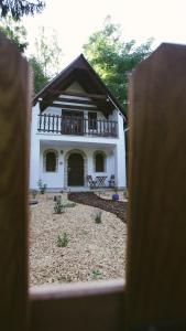 a white house with a balcony on top of it at Zöldre Néző Vendégház in Letkés