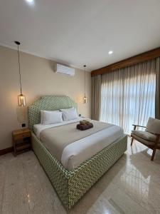 een slaapkamer met een groot bed en een raam bij Regina Suite in Bingin Beach +26 foto's