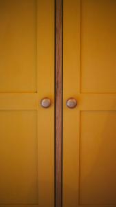 a close up of a yellow door with two handles at Zöldre Néző Vendégház in Letkés +15 photos
