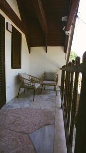 a porch with a couch and a chair in a house at Zöldre Néző Vendégház in Letkés