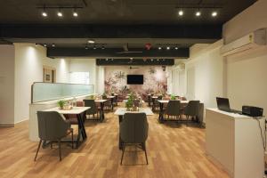 a dining room with tables and chairs and a tv at Stae Hotel-Gachibowli in Hyderabad