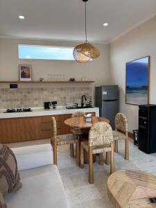 een keuken en woonkamer met een tafel en stoelen bij Regina Suite in Bingin Beach