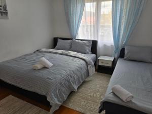 a bedroom with a bed and a window with blue curtains at Apartman SAN in Sarajevo