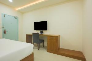 a bedroom with a bed and a desk with a television at Stae Hotel-Gachibowli in Hyderabad