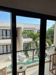 uitzicht vanaf de deur op een balkon met een palmboom bij Regina Suite in Bingin Beach