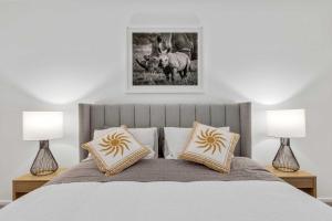 a bedroom with a bed with two lamps at Hathaway Haven in Alfredton