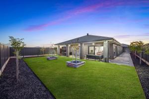 un patio trasero con una casa con césped en Hathaway Haven, en Alfredton