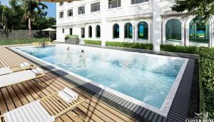 清迈The Clover的一个带椅子的游泳池和一栋建筑物