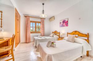 a bedroom with two beds and a desk at Ideal Property Mallorca - Eden Lago in Alcudia +31 photos