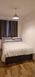 a bedroom with a large bed with a window at Cosy one bedroom flat in Chatham +3 photos