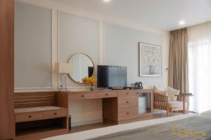 a bedroom with a desk with a tv and a mirror at Maison Lake View Luang Prabang in Luang Prabang