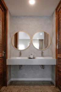 a bathroom with two sinks and two mirrors at Maison Lake View Luang Prabang in Luang Prabang