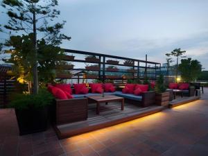 a patio with a couch and a table with red pillows at The Chambers Hotel in George Town