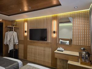 um quarto de hotel com televisão e um quarto em Nile Bride 5-Star Suite-Based Luxury Cruise - Every Monday from Luxor 4 & 7 Nights - Every Friday from Aswan 3 & 7 Nights em Luxor