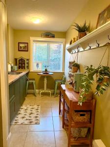 une cuisine avec des armoires vertes, une table et une fenêtre dans l'établissement A perfect getaway by the sea in North Nanaimo, à Nanaimo