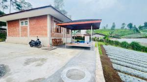 a house with a motorcycle parked in front of it at Villa bata ciwangun in Tegalharendong