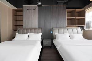 two beds sitting next to each other in a room at Shanpanyisu Hotel in Chongqing