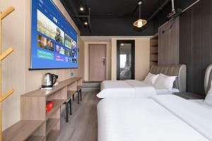 a room with three beds and a large screen at Shanpanyisu Hotel in Chongqing