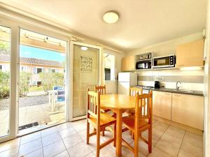 a kitchen with a table and chairs and a kitchen with a window at Domaine Soleil & Vignes, 4 pers Piscine à Calvisson in Calvisson +16 photos