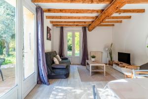 Una sala de estar con un sofá y un televisor. en Maisonnette Provençale, en Le Thor