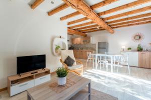 Una sala de estar con un televisor y una mesa. en Maisonnette Provençale, en Le Thor