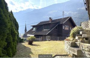 brązowy dom z kościołem w tle w obiekcie Apartment Ad Alta - Flattach w mieście Flattach