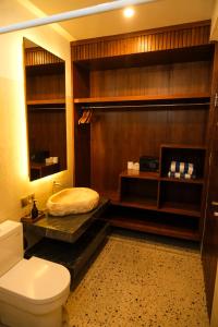 a bathroom with a toilet and a bed in it at Khamara Nusa Penida in Nusa Penida