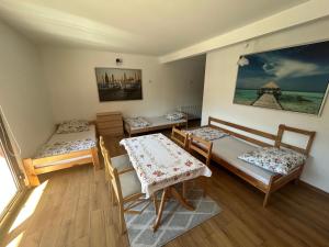 a room with three beds and a table and chairs at Jabłoń w Ogrodzie in Częstochowa
