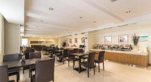 ChangshuにあるJinjiang Inn Central Changshu Yushanの黒いテーブルと椅子のあるレストラン、バー