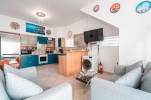 cocina y sala de estar con armarios azules en Haraki Beach Mediterranean Retreat, en Charaki