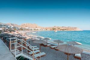 Una playa con sombrillas y sillas y el océano. en Haraki Beach Mediterranean Retreat, en Charaki