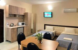 Cette chambre comprend 2 lits, une table et une télévision. dans l'établissement Панорама- стаи за гости, à Svishtov