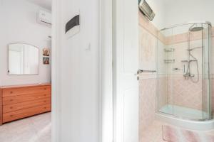 un baño con ducha y lavabo en Haraki Beach Mediterranean Retreat, en Charaki 22 fotos más