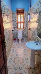 a bathroom with a toilet and a sink at Greg j & m suites in Kira