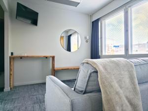Una sala de estar con una silla y un espejo. en Nature Hotel Kuutti, en Savonlinna