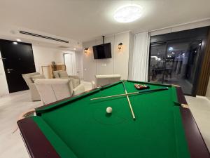 a pool table in a living room with a room with chairs at מתחם שמיים ותכלת נתניה in Netanya