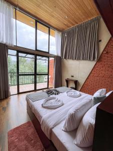 a large bed in a room with a large window at Ella Tea Heaven Resort in Ella