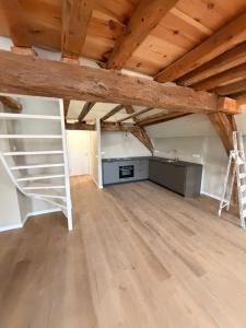 ein Zimmer mit Küche und Treppe auf dem Dachboden in der Unterkunft House of De Swaen Apartments in Breda